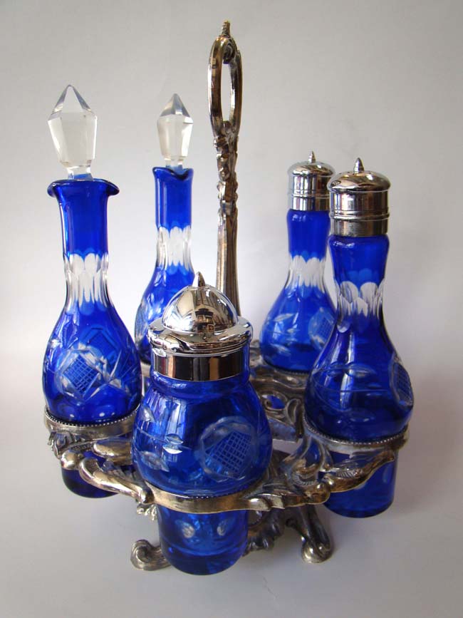 A fabulous vintage cruet set with five cobalt blue etched glass bottles on a silver plated stand.